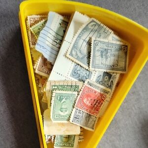 Assorted Vintage Postage Stamps in Yellow Holder